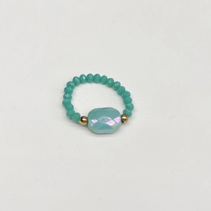 Detailed view of iridescent square gemstone ring with blue beaded elastic band and gold accents