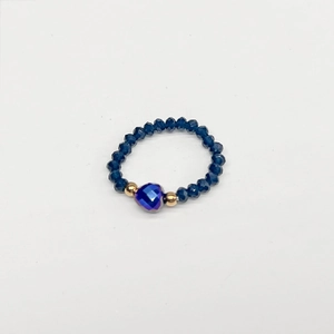 Detailed macro view of elastic beaded ring featuring heart-shaped blue iridescent gem