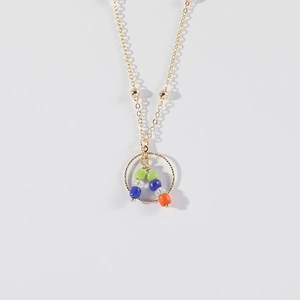Minimalist gold necklace with hollow ring pendant and colorful beaded accents on white background