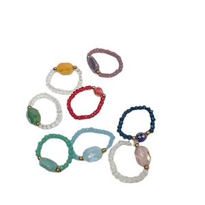 Set of 7 colorful handmade beaded stretch rings with faceted gemstones and golden accents
