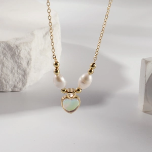 Collier élégant en acier titane doré avec pierre œil de chat et deux perles nacrées