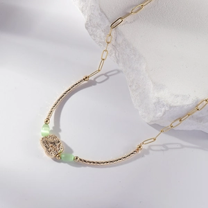 Elegant 14K gold plated necklace with twisted metal bars and green cat eye stone pendant