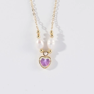 Élégant collier doré avec pendentif cœur violet et perles blanches sur fond blanc