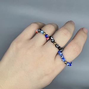 Bohemian Evil Eye beaded elastic ring with colorful glass charms on a model's hand