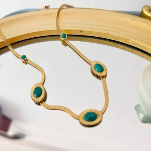 Détail du collier chaîne serpent dorée 18K orné de cinq pierres ovales vertes