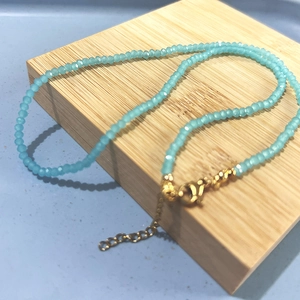 Detail of light blue crystal beaded necklace with golden lobster clasp and extender