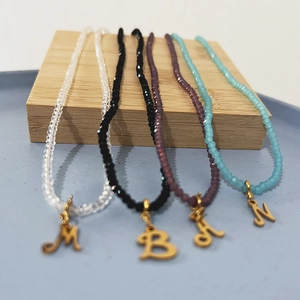 Colorful bohemian crystal beaded necklace featuring gold letter pendants M B A N