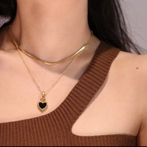 Double-layered gold titanium steel necklace featuring snake chain and black heart pendant