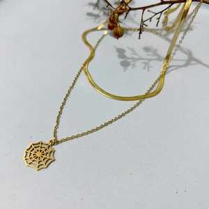 Double-layered gold snake chain necklace featuring a minimalist spider web charm pendant