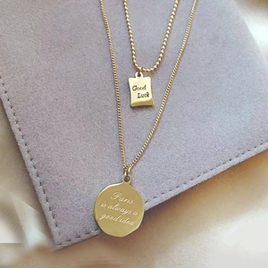 Macro view of 18K gold-plated double-layer necklace with Good Luck engraved pendants