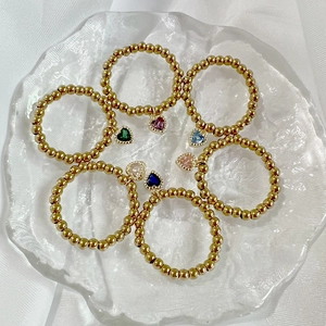 Detailed set of six golden beaded elastic rings with colorful heart shaped pendants