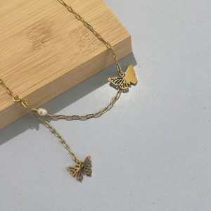 Élégant collier en acier titane doré avec pendentifs papillons et une perle blanche