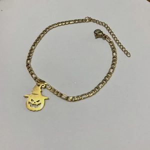 Gold titanium steel Figaro chain bracelet featuring a hollow Jack-o'-lantern pumpkin charm