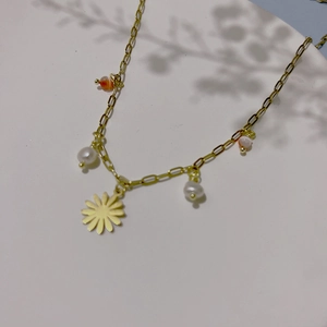 Detail of daisy flower pendant necklace with pearls and cat eye beads on gold chain