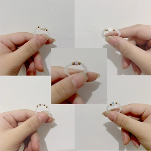 Five assorted handmade stainless steel beaded rings with diverse decorative charms