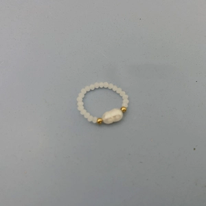 Detail of beaded ring featuring white faceted beads and a baroque pearl with gold accents