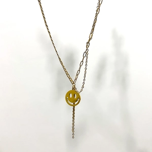 Close-up of 18K gold smile pendant necklace with unique paperclip and round link chains