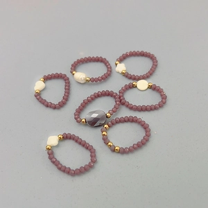 Vue détaillée de 7 bagues perlées violettes élastiques avec perles dorées et cœurs