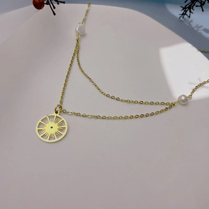 Collier doré avec pendentif rayon de soleil et perles blanches sur double chaîne