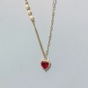 Détail du collier coeur rouge avec perles asymétriques et maillons dorés fins