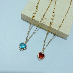 Détail du collier chaîne dorée avec pendentifs cœur en zircon et accents de perles