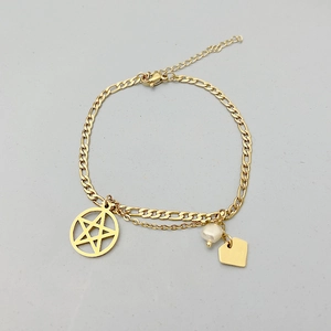 Détail d'une chaîne Figaro en acier titane doré avec pendentifs étoile et cœur