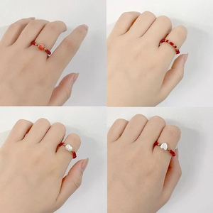 Detailed views of handmade red crystal beaded rings with shell and pearl accents