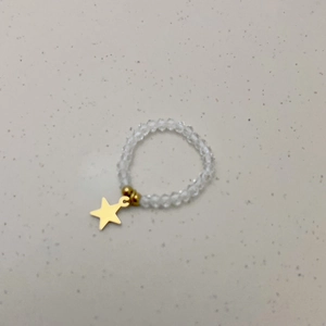 Detail van elastische kralenring met kristallen kralen en gouden sterhanger