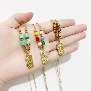 Three gold vintage evil eye necklaces with colorful beads and engraved mystical pendants