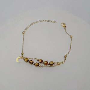 Detail of gold layered star moon bracelet with textured cube beads and lobster clasp