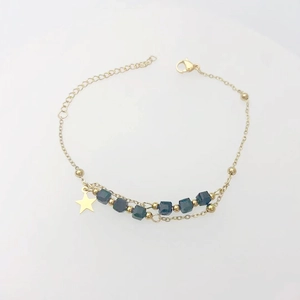 Detailed view of gold star moon bracelet with dark blue cube beads and adjustable lobster clasp