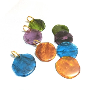 Detail showing four pairs of resin pebble earrings in green, purple, orange, and blue colors