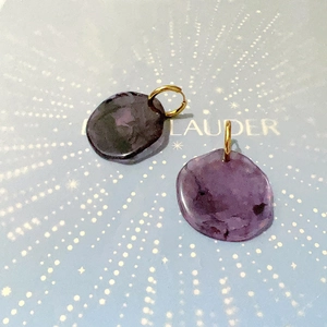 Macro detail of French vintage purple resin round earrings with gold titanium steel hooks