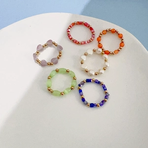 Set of 6 colorful crystal stone beaded elastic rings with gold metal spacers in a white tray