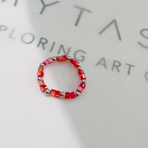 Detailed shot of red faceted crystal beads and silver steel balls on a stretch ring