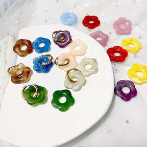 Boucles d'oreilles fleurs en résine marbrée et anneaux dorés en acier titane