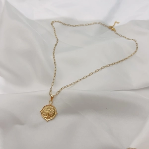 Close-up of 18K gold plated tree of life pendant on a stylish paperclip chain