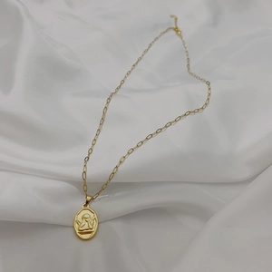 Detail shot of vintage 18K gold plated oval Cupid angel pendant on a paperclip chain