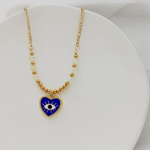 Détail du collier doré avec pendentif cœur œil bleu et chaîne perlée raffinée