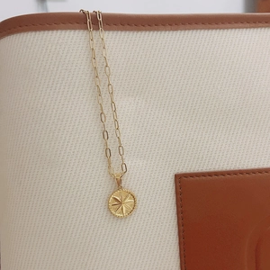 Détail du collier à maillons trombone plaqué or 18K avec pendentif soleil gravé
