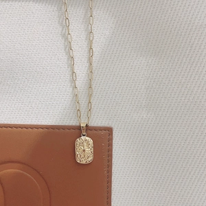 Détail du collier chaîne trombone en or 18K avec pendentif rectangulaire à motif étoile