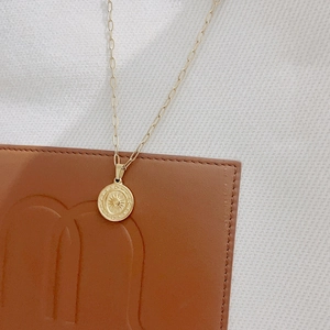 Gros plan du pendentif étoile en or 18 carats sur une chaîne en cuir marron