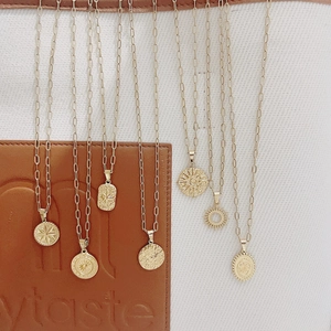 Colliers en acier doré 18K avec pendentifs étoile et tournesol sur fond en toile