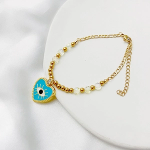 Détail du bracelet cœur mauvais œil avec perles dorées et perles de cristal irisées