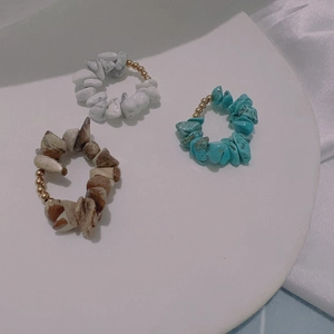 Anillos estilo bohemio de piedras naturales y cuentas doradas en bandeja blanca