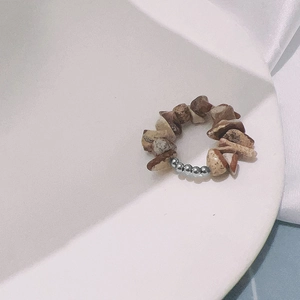 Detalle de anillo elástico hecho a mano con piedras naturales y cuentas de acero