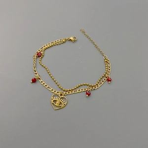 Detail of gold double-layer chain with red evil eye beads and hollow heart pendant