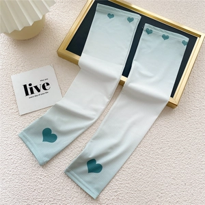 Detail of gradient blue-white ice silk cooling sleeves with green heart prints on fabric