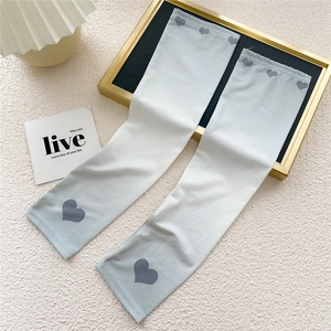 Detail of light blue gradient cooling arm sleeves with grey heart patterns on elastic fabric