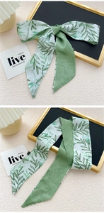 Détail d'un foulard en soie à imprimé feuilles avec nœud papillon et texture lisse